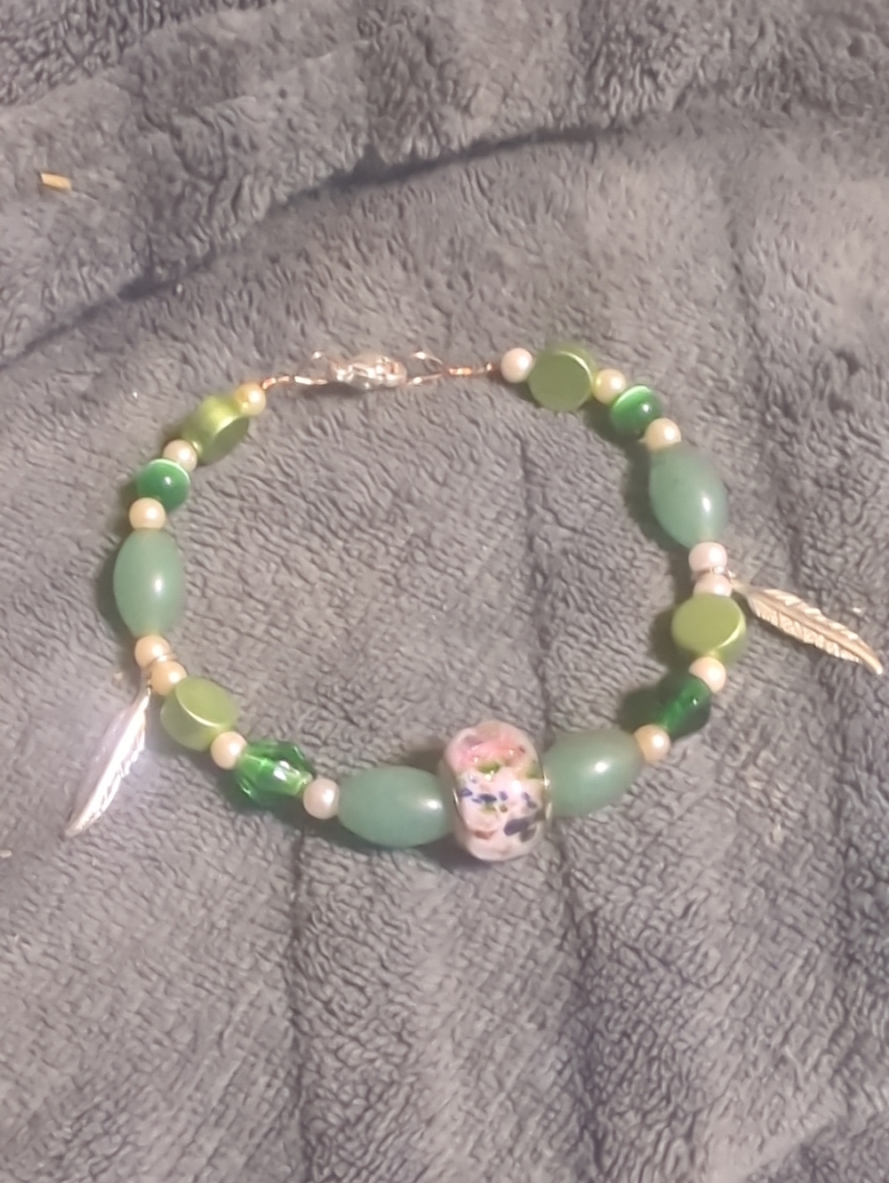 Green Beaded Bracelet with Floral Glass Accent and Gold Feather Charms